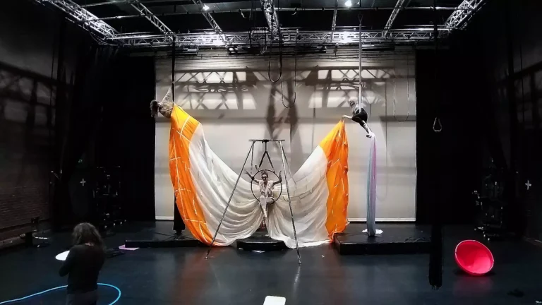 Three aerialists performing in a theatre