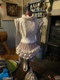 A piece of beige/dusky pink costume displayed on a female half-body mannequin